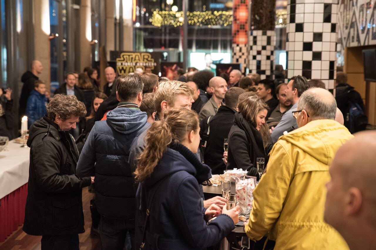 "crowded lounge with people drinking champagne at the star wars premiere"